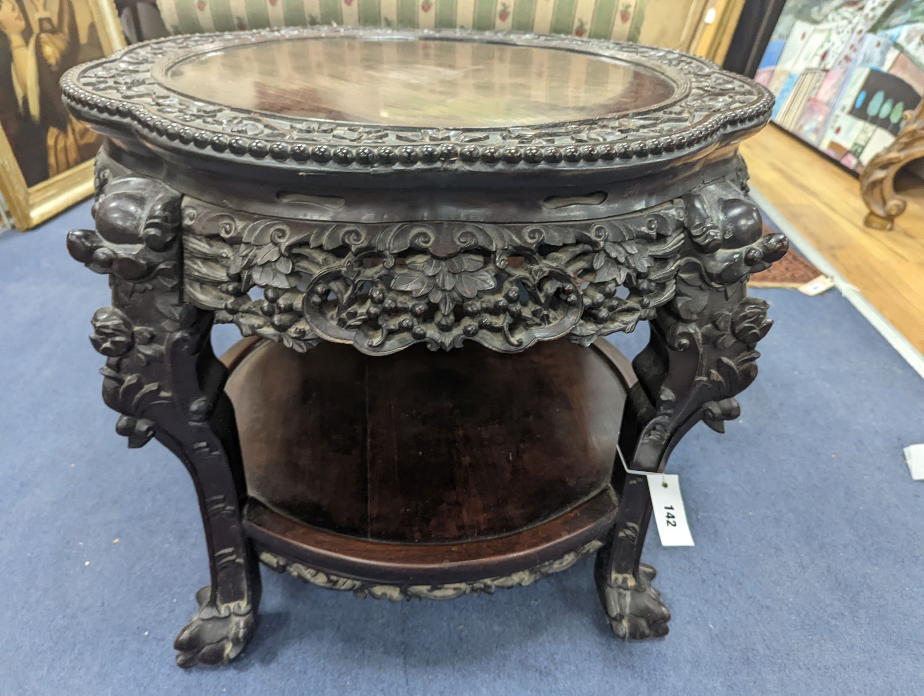 An early 20th century Chinese carved hardwood two tier table, diameter 64cm, height 56cm